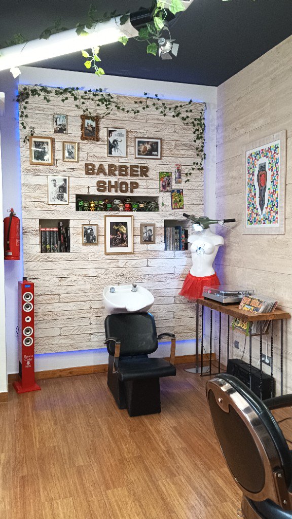 Zona de rentat amb paret decorada i cadira de barberia a Hidalgo Junior.
