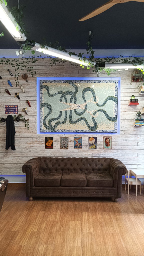 Sala d'espera amb sofà Chesterfield i decoració amb mosaic a Hidalgo Junior.